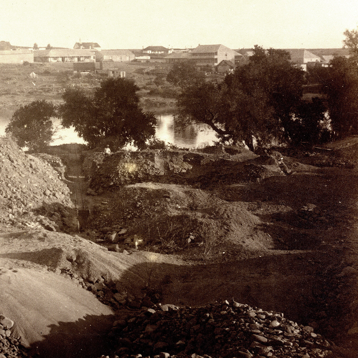 A serene dirt road meanders alongside a sparkling river, evoking the timeless allure of diamond history.
