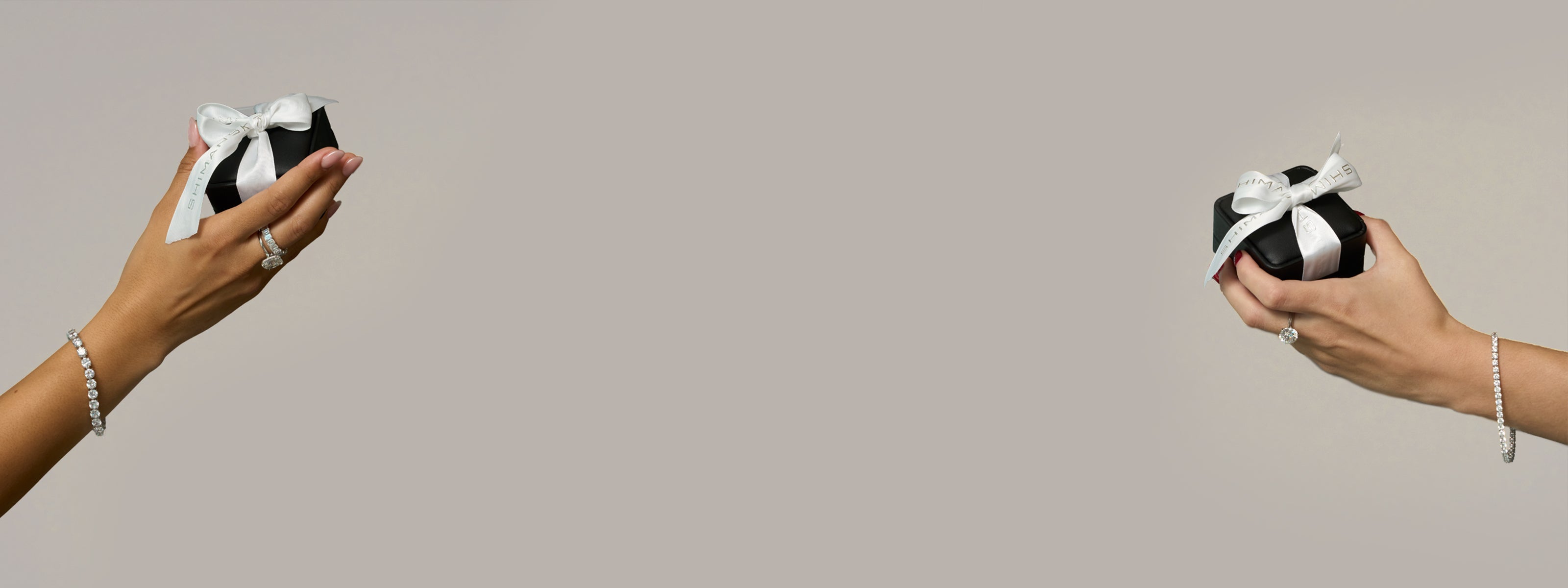 Two models hold Shimansky jewellery gift boxes adorned with diamond jewellery