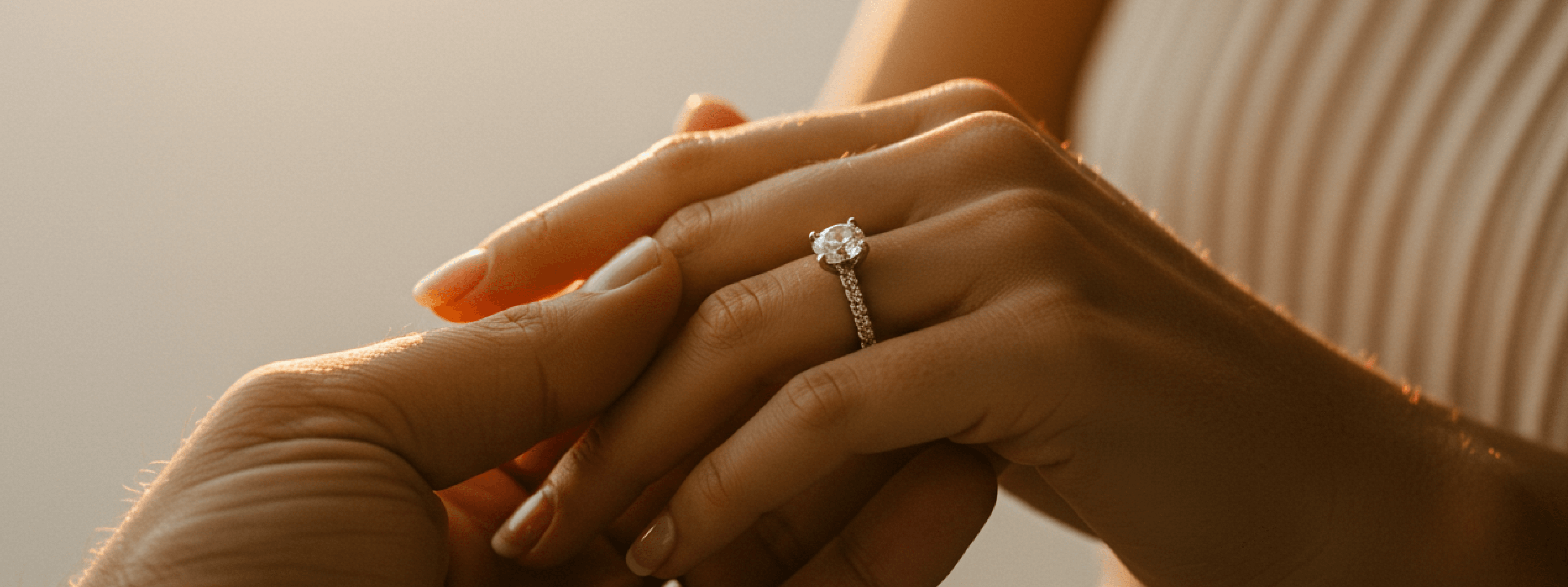 Close-up of hands with a diamond ring on a soft background