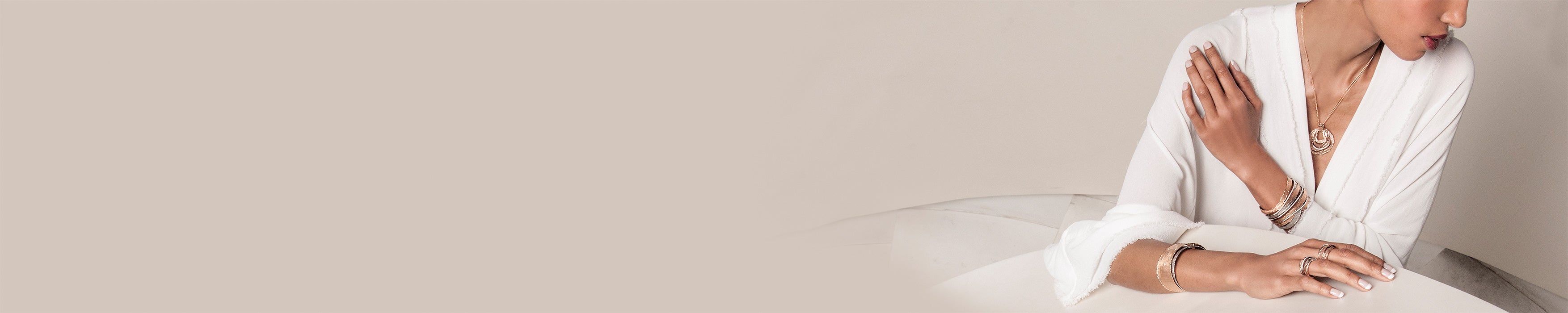 A sophisticated woman in a crisp white shirt, radiating elegance with her stunning jewelry pieces.
