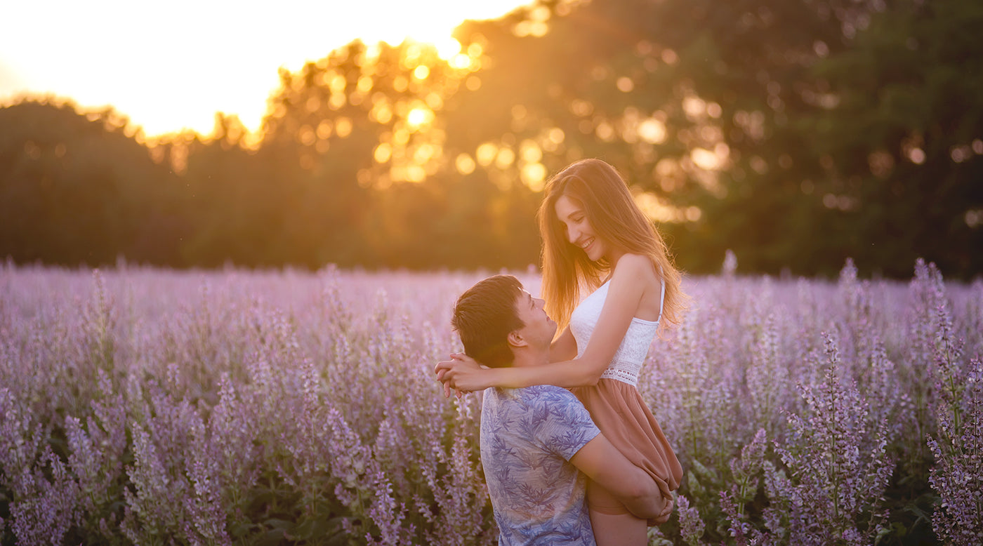 A romantic moment captured as a man and woman embrace in a lush lavender field, surrounded by fragrant purple blossoms.