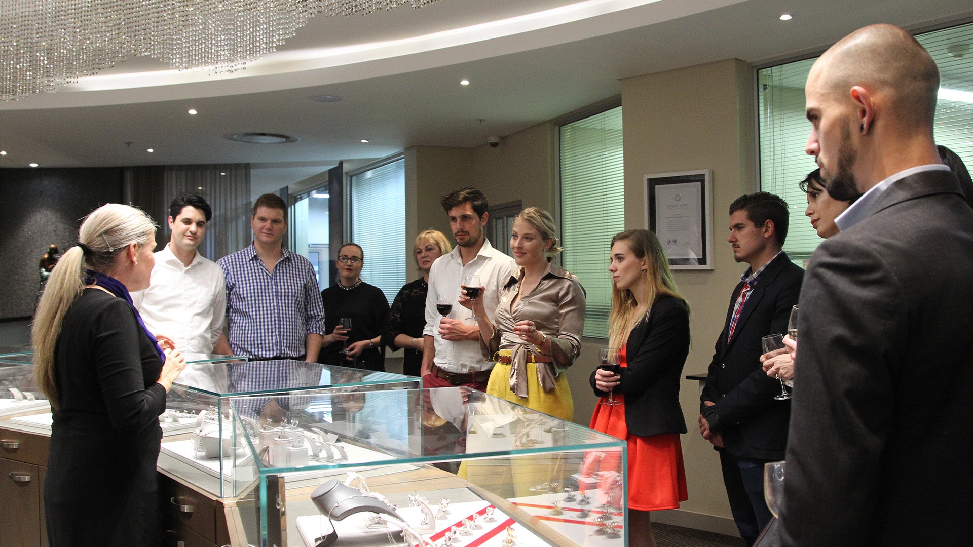 A group of visitors admiring a display case at the Cape Town Diamond Museum, surrounded by sparkling gems and history.