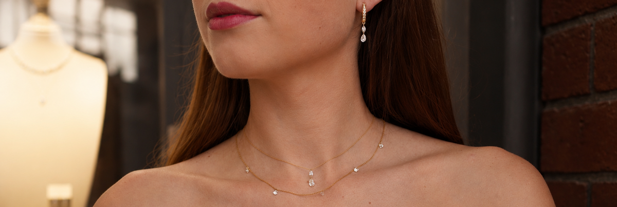 Two Shimansky yellow gold Frameless necklaces with freely-set spaced diamonds with no visible setting, layered at the collarbone.