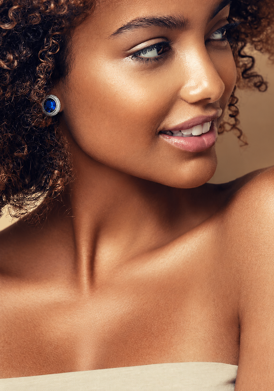 Shimansky Tanzanite stud earring surrounded by a diamond halo, worn on the ear