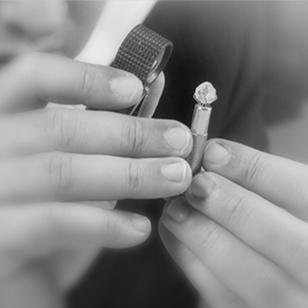 CEO Yair Shimansky closely inspecting a diamond under a microscope