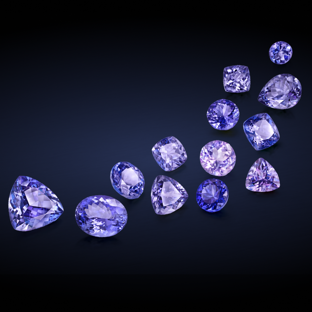 Shimansky violet-blue Tanzanite in assorted faceted cuts and varying sized Tanzanite arranged diagonally across a dark navy background.
