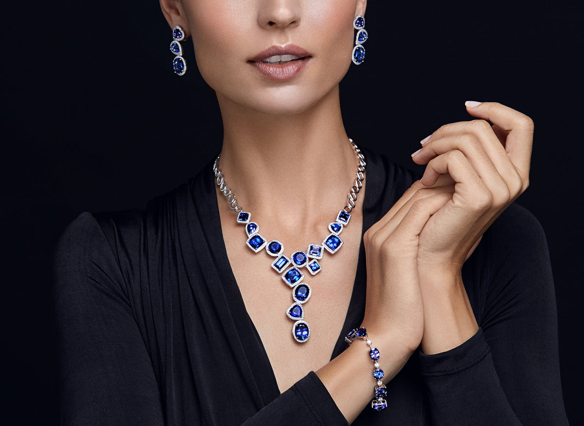 Shimansky tiered Tanzanite necklace with diamond halos, matching Tanzanite drop earrings and bracelet, worn with black.