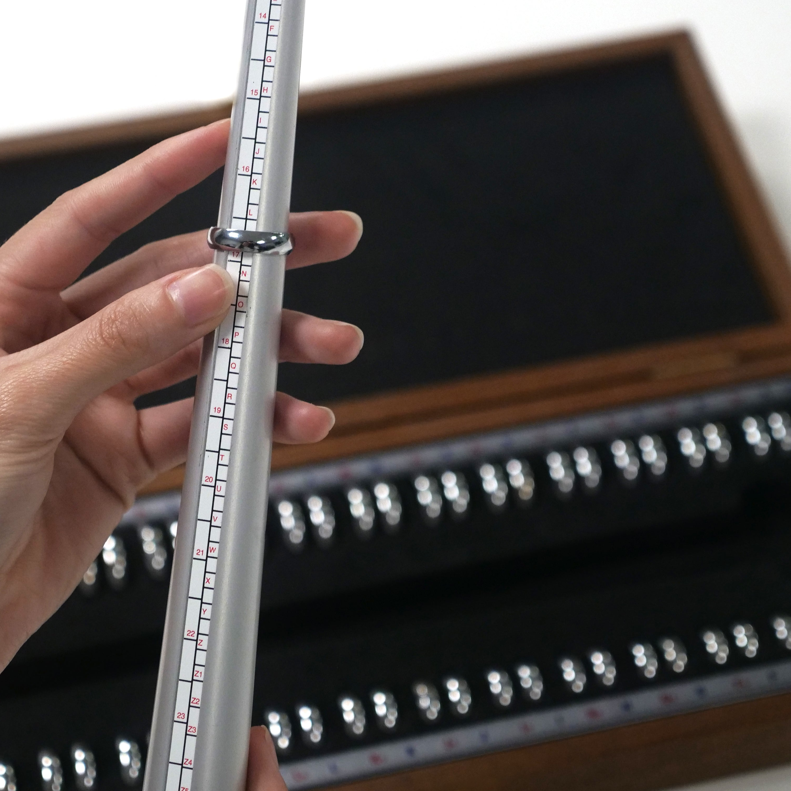 An individual holding a ring sizer emphasizing accuracy and the importance of measurement of a ring size.