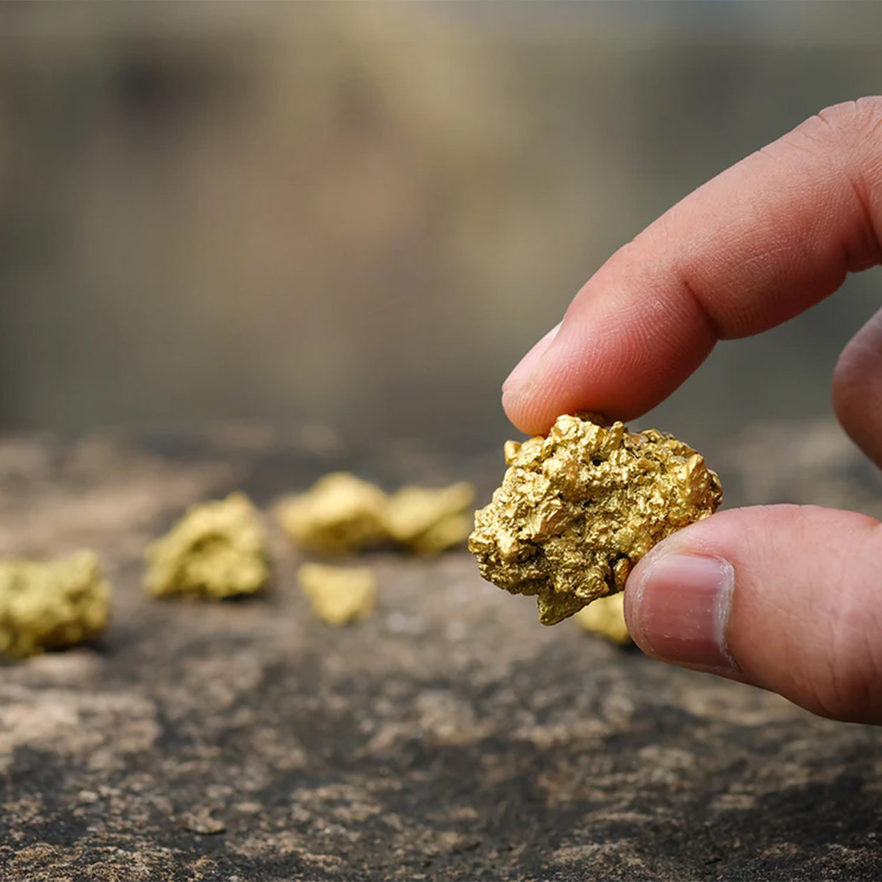 A man picking up a loose piece of gold