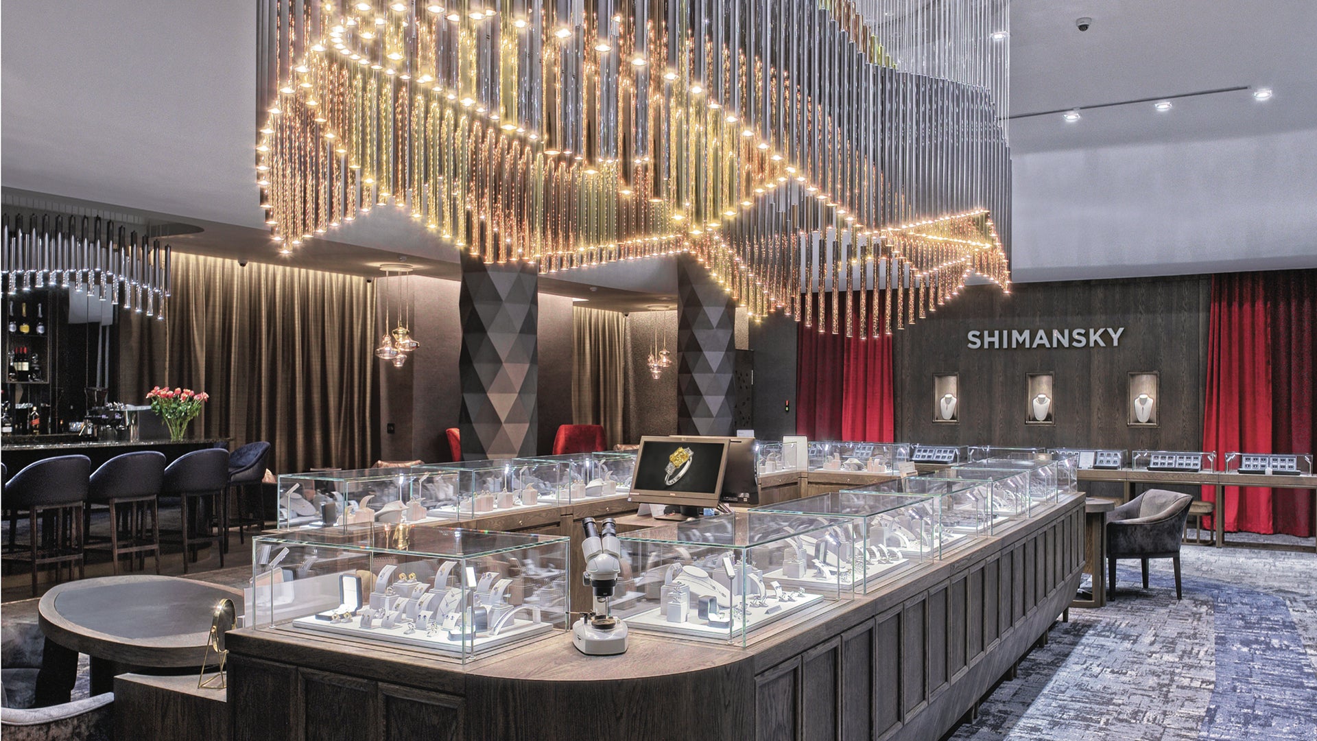 A luxurious showroom featuring a grand chandelier and an elegant bar, showcasing Shimansky Rockwell's exquisite designs.