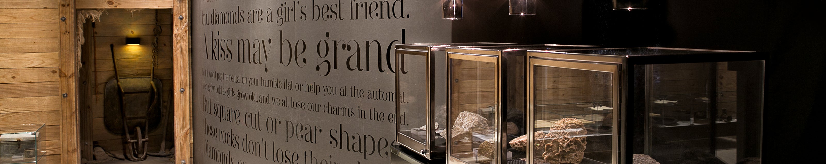 An elegant display case filled with stunning diamonds, featuring a refined sign on the wall at the Cape Town Diamond Museum.