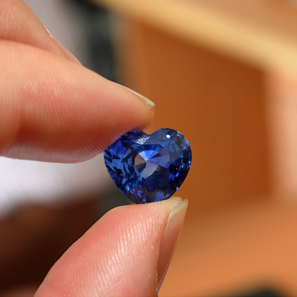 Person holding a heart shaped cut Tanzanite