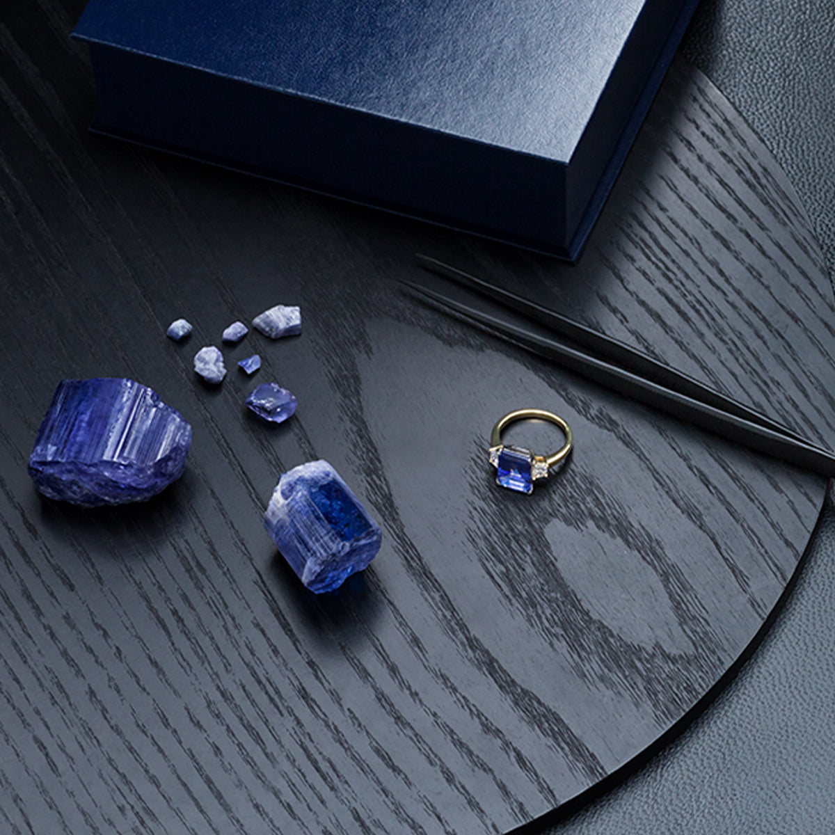 Shimansky Jewellers sorting loose rough tanzanite next to a Tanzanite Trilogy Ring