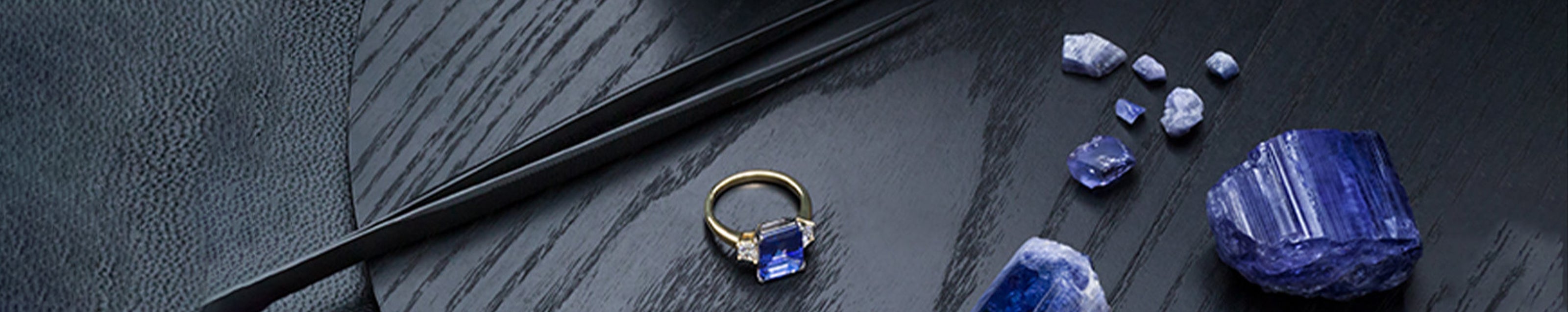 An elegant ring featuring stunning Tanzanite, artfully arranged on a refined table setting.