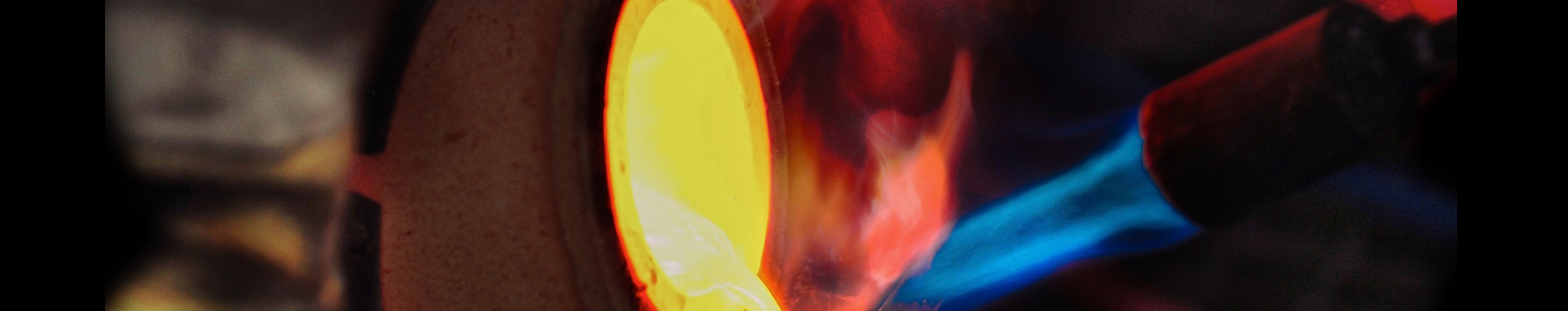 An intimate shot of a metal being heated, showcasing the vibrant hues of molten metal in the backdrop.