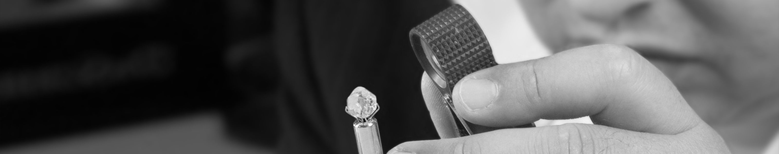 A person delicately holds a small Shimansky diamond, showcasing its exquisite brilliance and elegance in their hand.