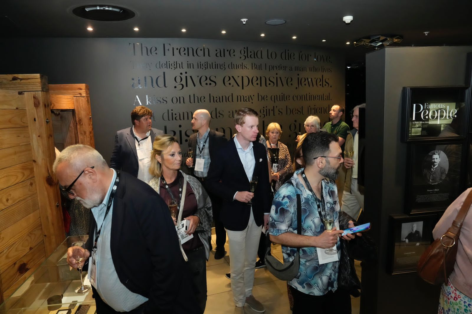 A group of people admiring exquisite items on display at the Cape Town Diamond Museum, surrounded by elegance and luxury.