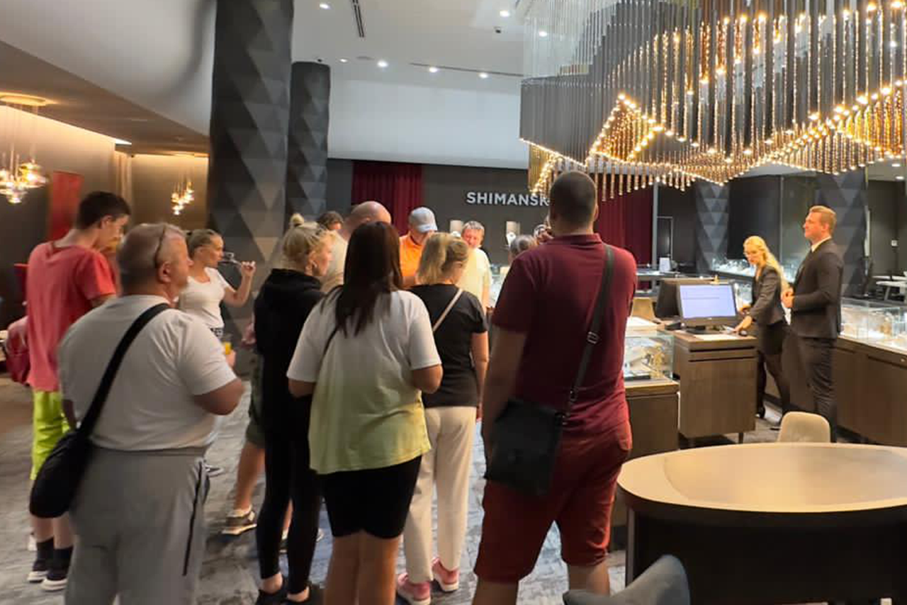 Guests enjoy a luxurious atmosphere under a grand chandelier at the Shimansky Rockwell Showroom.